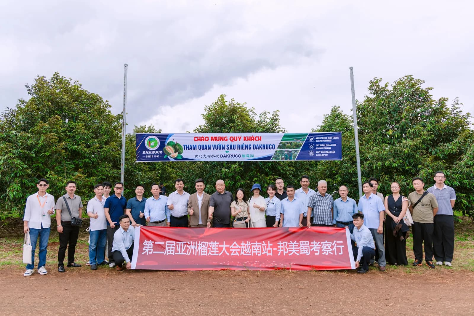 Đoàn khảo sát chụp ảnh tập thể trước băng rôn chào mừng tham quan vườn sầu riêng Dakruco tại Đắk Lắk