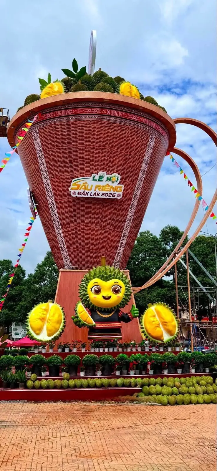 Mô hình gùi sầu riêng khổng lồ và linh vật sầu riêng, phía dưới xếp hàng trăm trái sầu riêng và cây cảnh