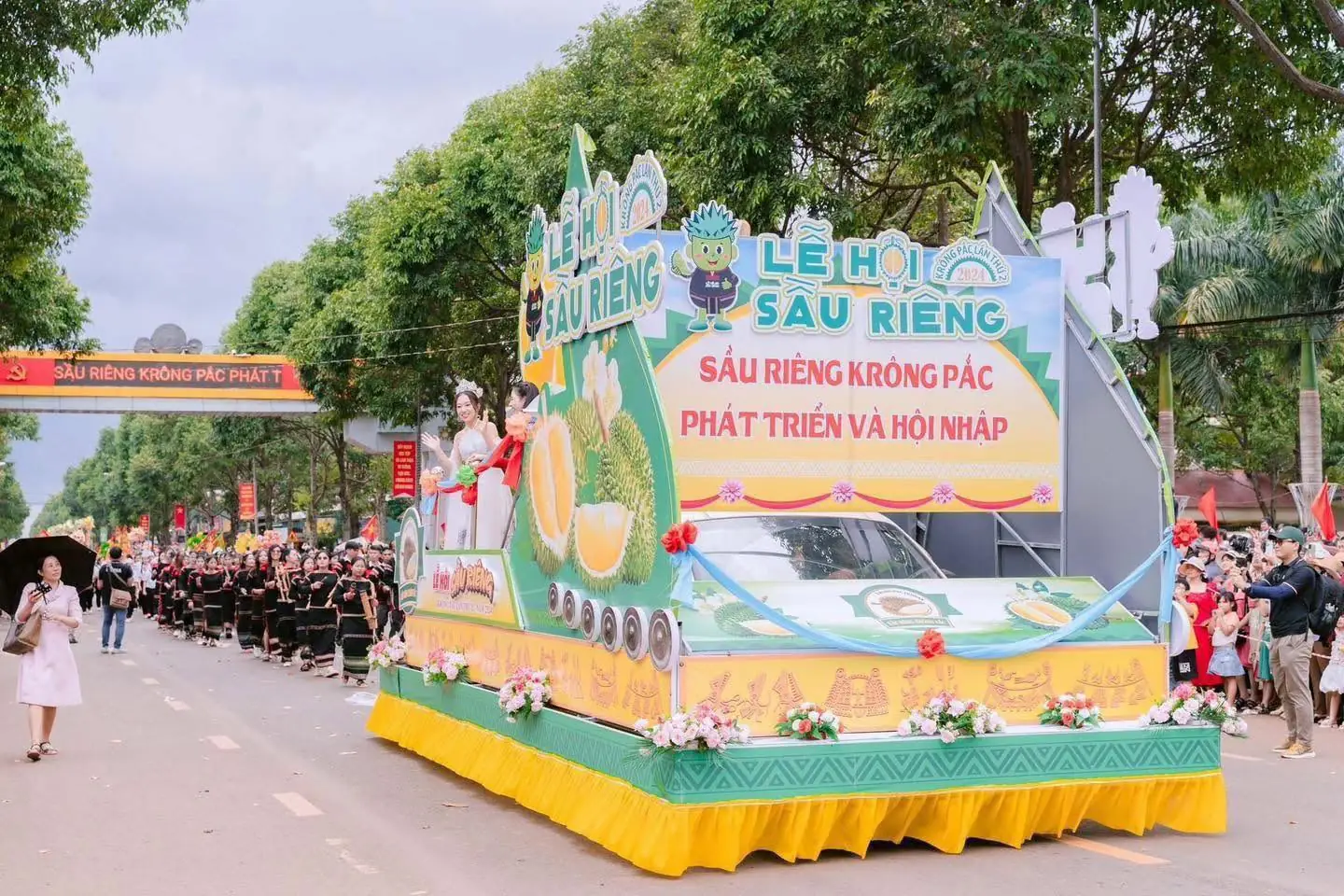 Xe diễu hành trang trí chủ đề sầu riêng đi giữa hai hàng người xem trên đường phố Krông Pắc